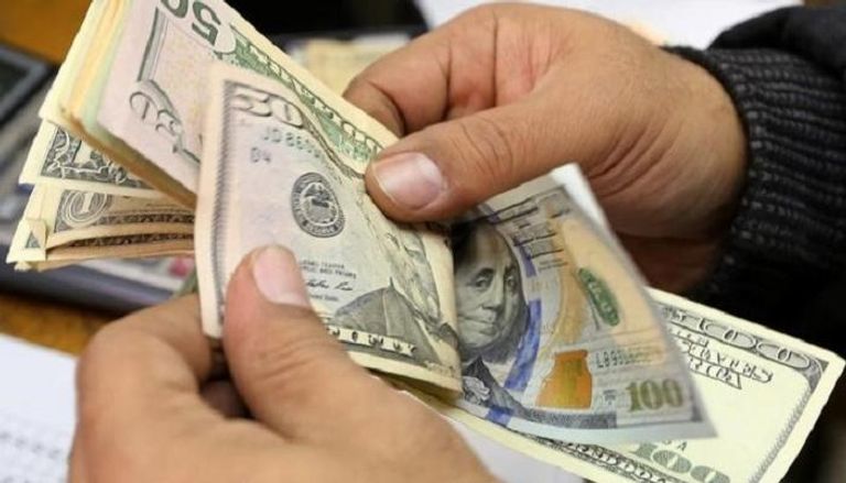 مصري يعد أوراقا من الدولار (رويترز)