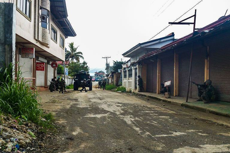 أحد الجنود يحمل طفلة تم إنقاذها من مدينة ماراوي (أ ف ب)