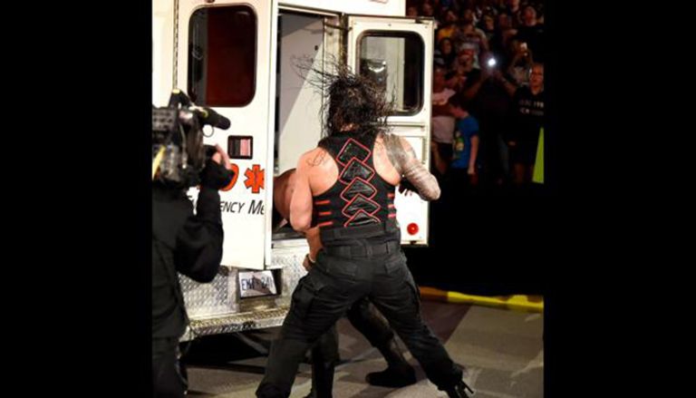 برون سترومان يحاول إدخال رومان رينز سيارة الإسعاف