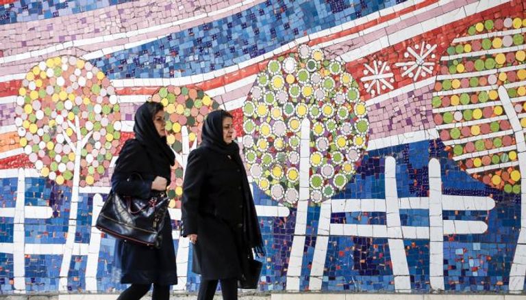 إيرانيتان تسيران بأحد شوارع طهران