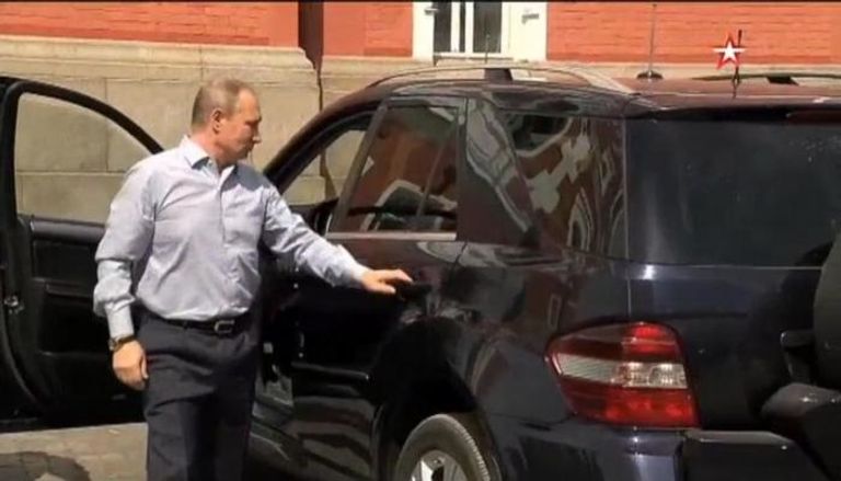 بوتين يفتح باب سيارته للمرأة الغامضة