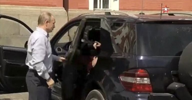 بوتين يفتح باب سيارته للمرأة الغامضة