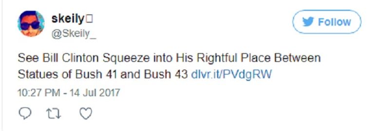 بيل كلينتون وسط تمثالي بوش الأب والابن