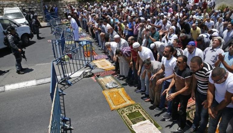 فلسطينيون يؤدون الصلاة خارج الأقصى  -أرشيفية
