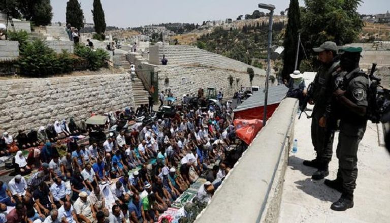 فلسطينيون يصلون خارج الأقصى (رويترز)