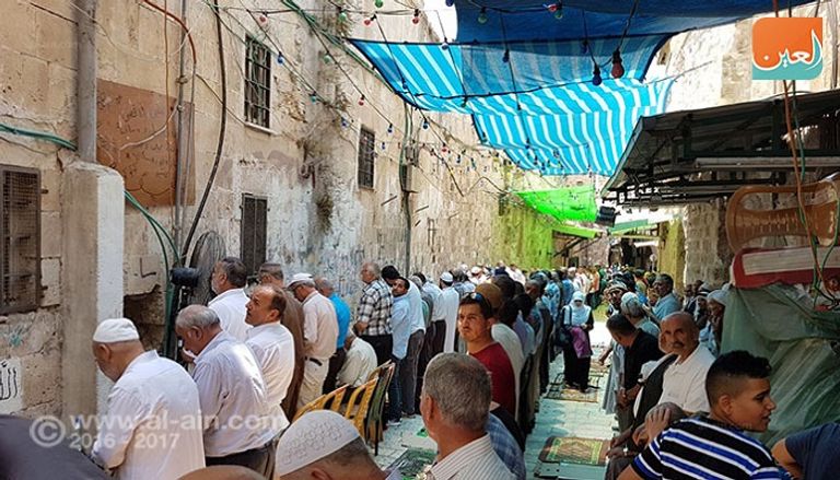 فلسطينيون يصلون خارج الأقصى (رويترز)