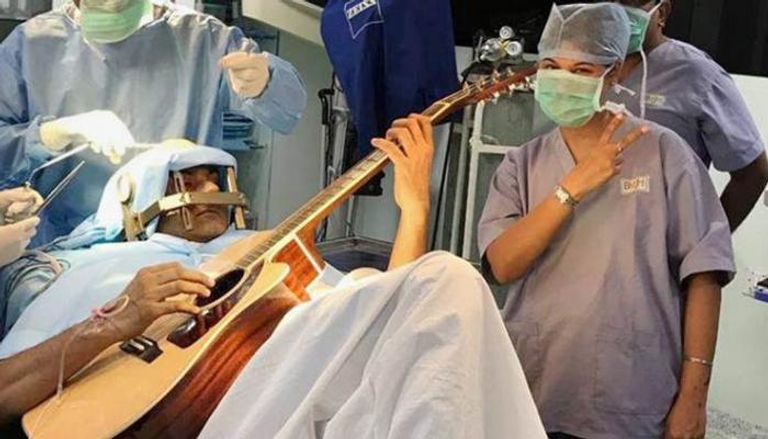 مريض يعزف الجيتار أثناء عملية جراحية