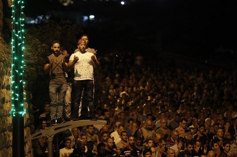 المحتفلون يهللون وهم يوزعون الحلوى عند باب الأسباط (الفرنسية)