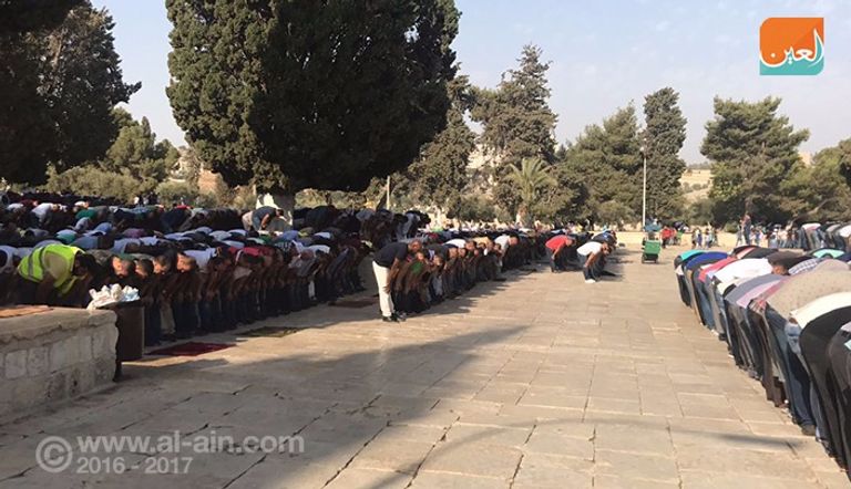 الفلسطينيون يرفعون العلم فوق إحدى بوابات الأقصى