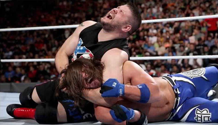 إيه جيه ستايلز يقوم بخنق كيفين أوينز