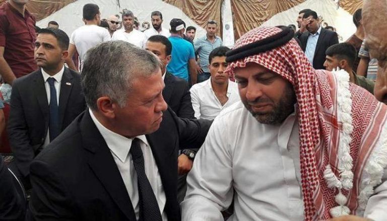 ملك الأردن خلال تقديم العزاء في أحدي قتيلي السفارة تشييع جثمان أحد القتيلين في الأردن (الفرنسية)