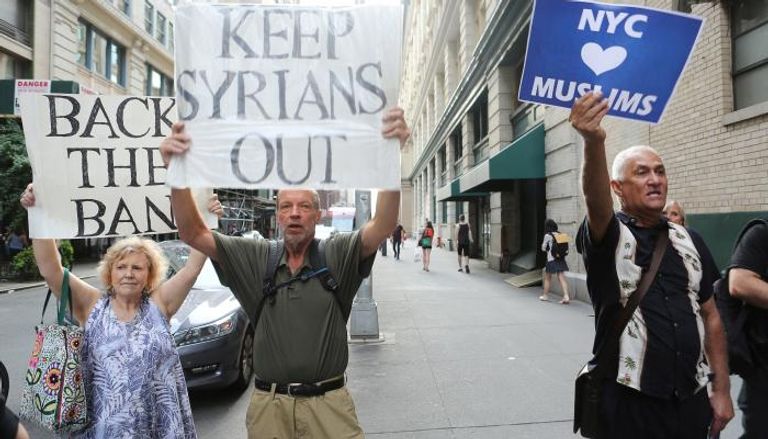 متظاهرون يرفعون لافتات معارضة لدخول اللاجئين للولايات المتحدة (رويترز)