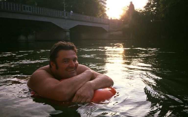 رجل يتغلب على زحمة المرور بالسباحة إلى العمل