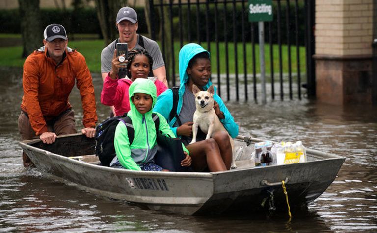 الابتسامة والمرح يهزمان دمار إعصار هارفي ناجون من الإعصار يبتسمون خلال نقلهم إلى أماكن آمنة (رويترز)