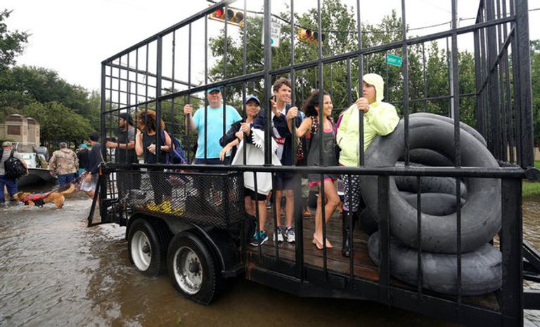 الابتسامة والمرح يهزمان دمار إعصار هارفي ناجون من الإعصار يبتسمون خلال نقلهم إلى أماكن آمنة (رويترز)