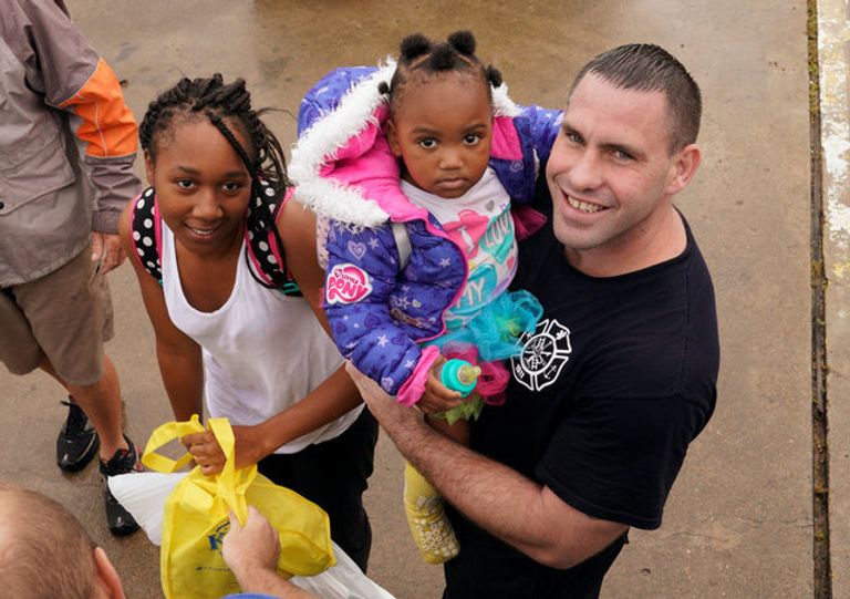 الابتسامة والمرح يهزمان دمار إعصار هارفي ناجون من الإعصار يبتسمون خلال نقلهم إلى أماكن آمنة (رويترز)