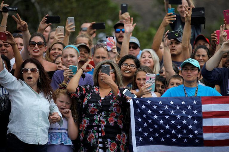 الابتسامة والمرح يهزمان دمار إعصار هارفي ناجون من الإعصار يبتسمون خلال نقلهم إلى أماكن آمنة (رويترز)