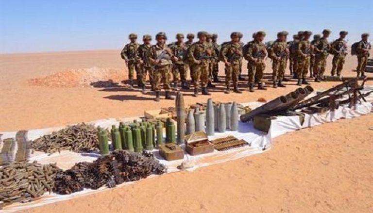 عناصر الجيش الجزائري أمامهم الأسلحة المضبوطة