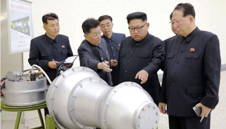 كيم جونج أون يتفقد رأسا نووية مع مساعديه ( وكالة الأنباء الكورية)