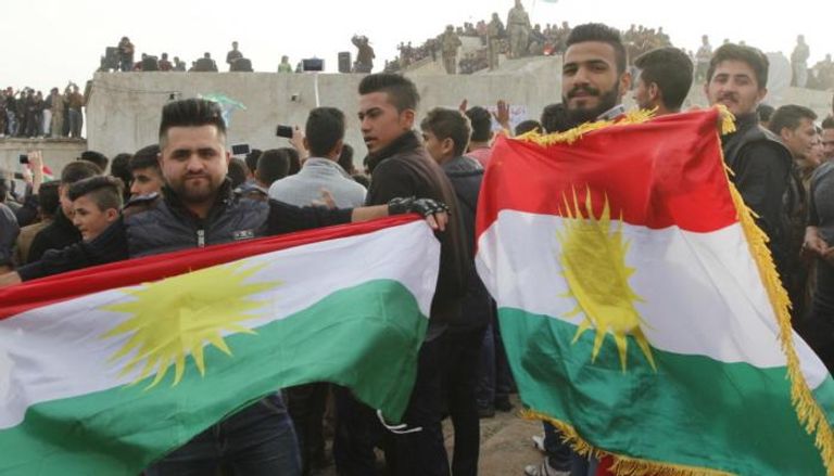 أكراد يرفعون علم إقليم كردستان