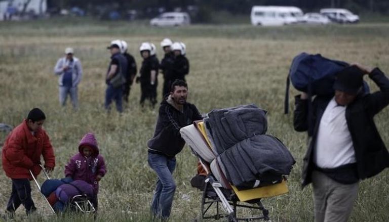 أسرة من المهاجرين بعد إخلاء معسكر للاجئين على الحدود اليونانية