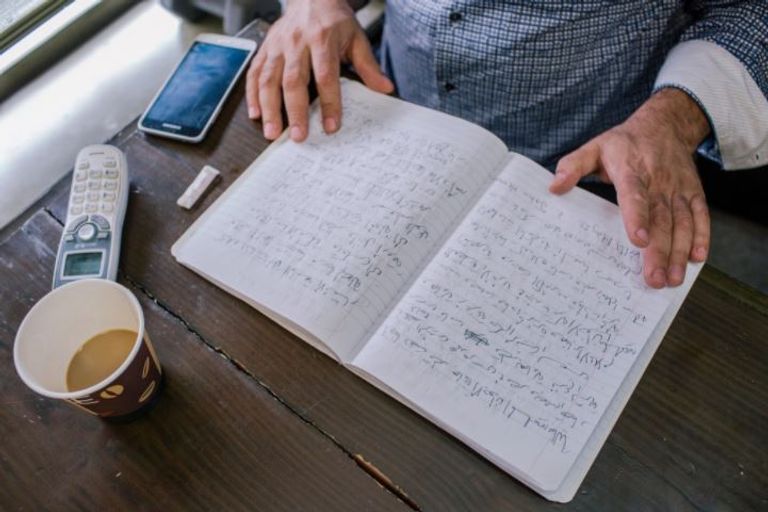 حاتم الجمسي من خلف أحد أرفف محل عمل السندويتشات (نيويورك تايمز)