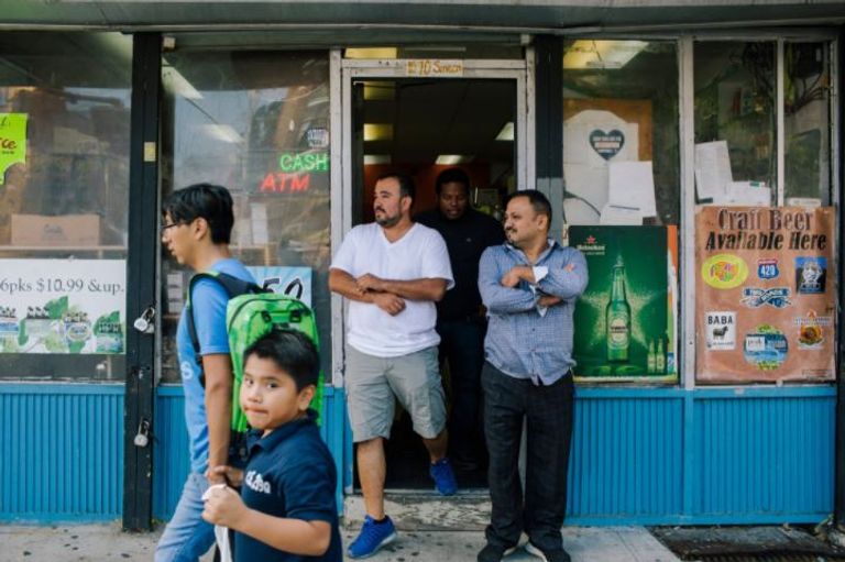 حاتم الجمسي من خلف أحد أرفف محل عمل السندويتشات (نيويورك تايمز)