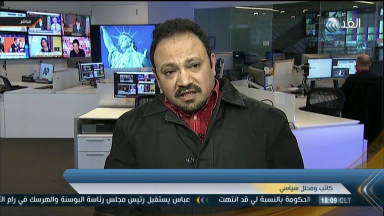 حاتم الجمسي من خلف أحد أرفف محل عمل السندويتشات (نيويورك تايمز)