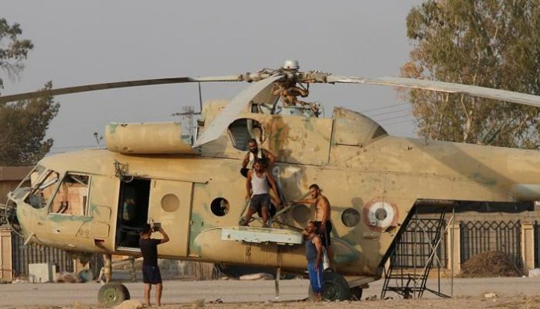 مواطنون يلتقطون صورة أمام طائرة عسكرية في دير الزور - رويترز