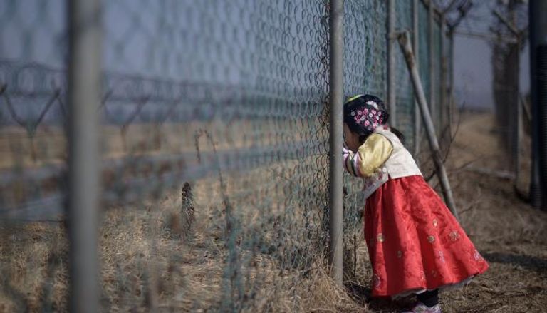 طفلة تقف على الحدود بين كوريا الشمالية والصين (أ ف ب)