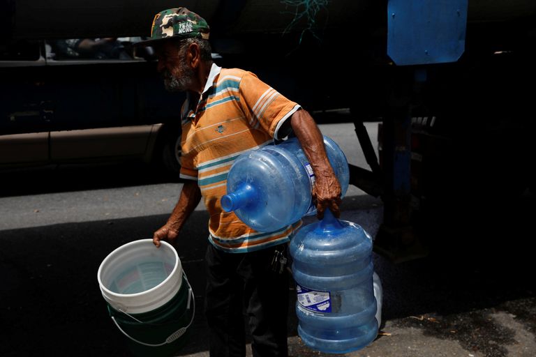 السكان يملؤون الأوعية بالمياه من بئر في بويرتو ريكو