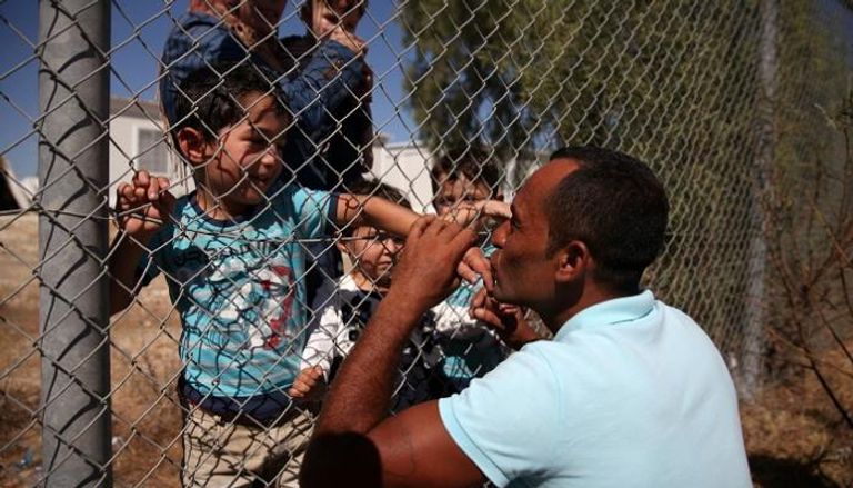 أب سوري يقبل أطفاله بعد جمع شملهم في قبرص
