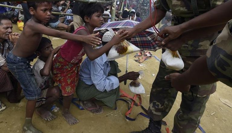 أطفال الروهينجا يتلقون المساعدات من الجيش في بنجلاديش - أ. ف. ب