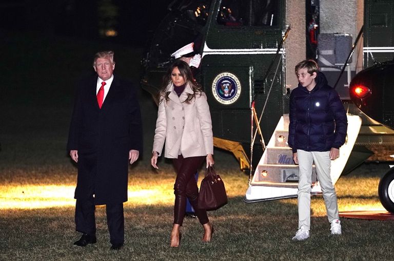 ترامب وزوجته وابنهما يصلون قاعدة أندروز ترامب ملوحا للكاميرات خلال مغادرته فلوريدا - رويترز