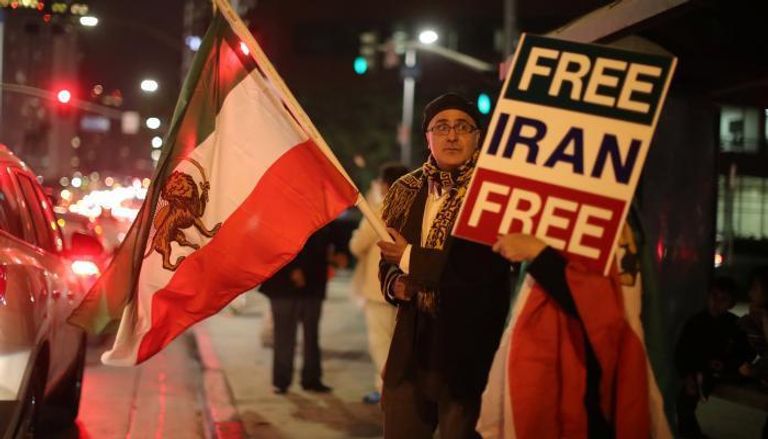 متظاهر ضد الملالي بلوس أنجلوس يحمل لافتة تقول "حرروا إيران"- رويترز