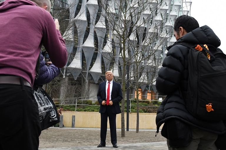 مراسلي وكالات الأنباء يلتقطون الصور للتمثال تمثال الرئيس ترامب أمام مقر السفارة الجديد - أ. ف. ب