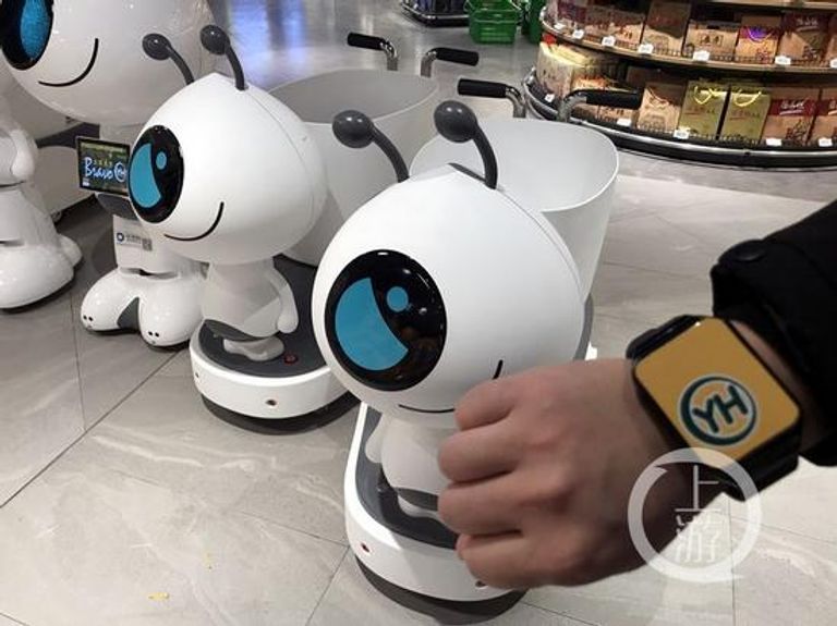 الروبوتات تعمل من خلال سوار إلكتروني خاص عربات التسوق الروبوتية تنتظر المشترين