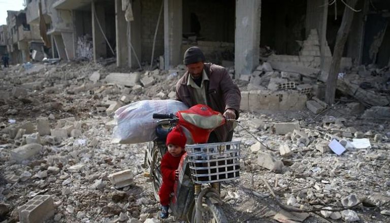 سوري ينقذ ما تبقى من حطام منزله عقب قصف للنظام - رويترز