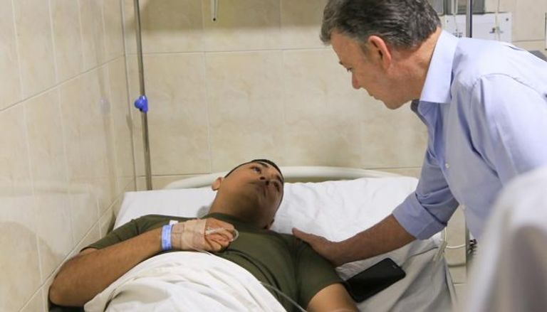 الرئيس الكولومبي يتفقد رجل شرطة مصابا - أ.ف.ب