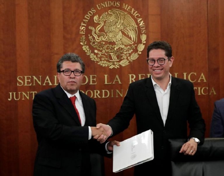 السيناتور المكسيكي ريكاردو موريل يصافح خوان كارلوس بيكر وكيل وزارة التجارة الخارجية المكسيكي  أعلام الولايات المتحدة وكندا والمكسيك - رويترز