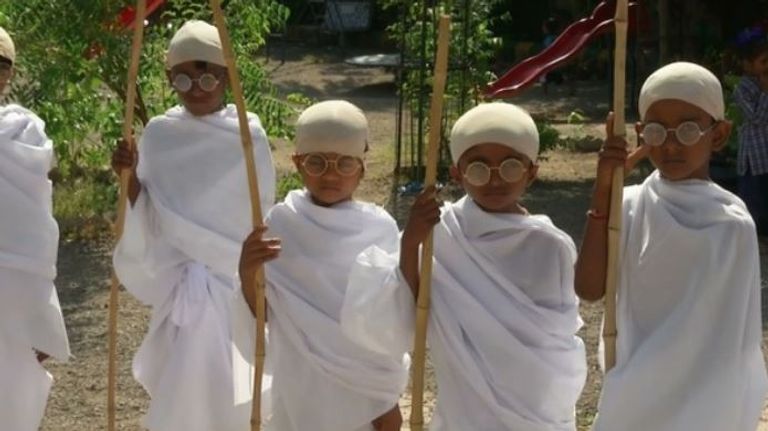 أطفال المدارس بالهند يحاكون هيئة غاندي