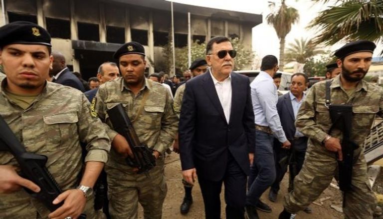 رئيس المجلس الرئاسي فايز السراج وسط عناصر المليشيات السراج يعين زعيم مليشيا وإخوانيا في حكومة الوفاق الليبية