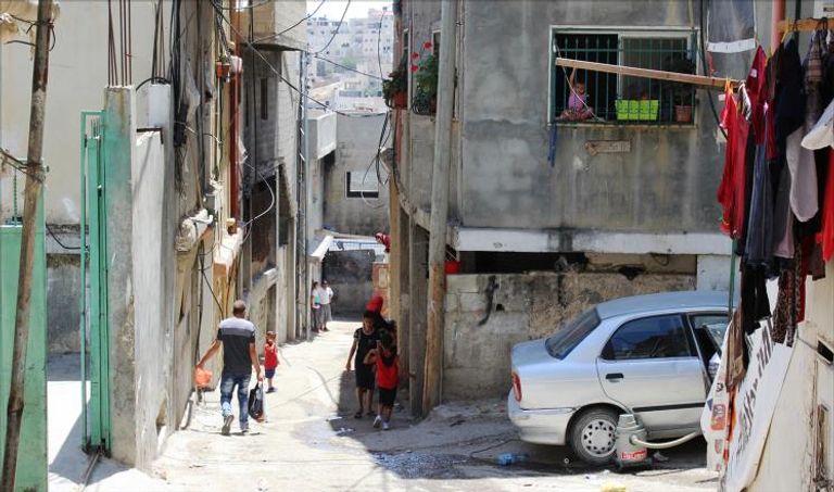 مخيم شعفاط في القدس  متظاهر فلسطيني يرفع علم الأمم المتحدة في مسيرة احتجاجية ضد قرار واشنطن