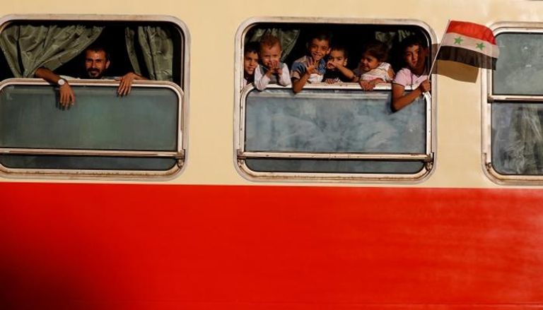 أطفال سوريون يطلون من نافذة قطار بدمشق