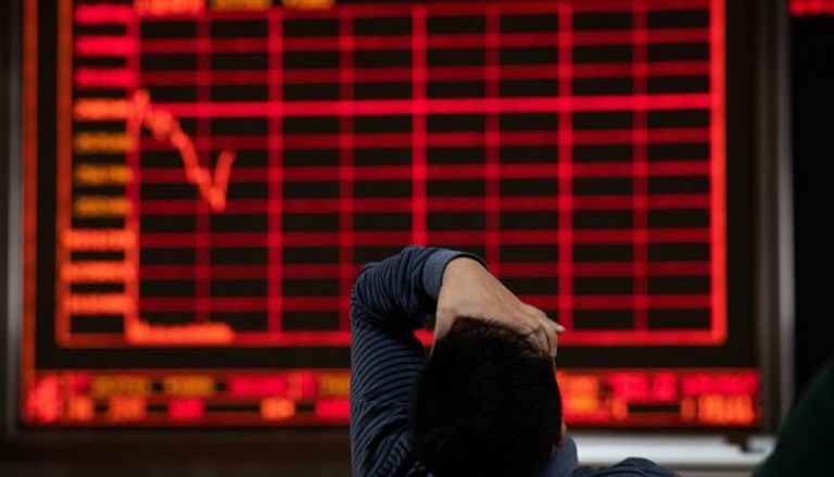 مستثمر يتابع هبوط الأسهم في بورصة بكين، الجمعة 