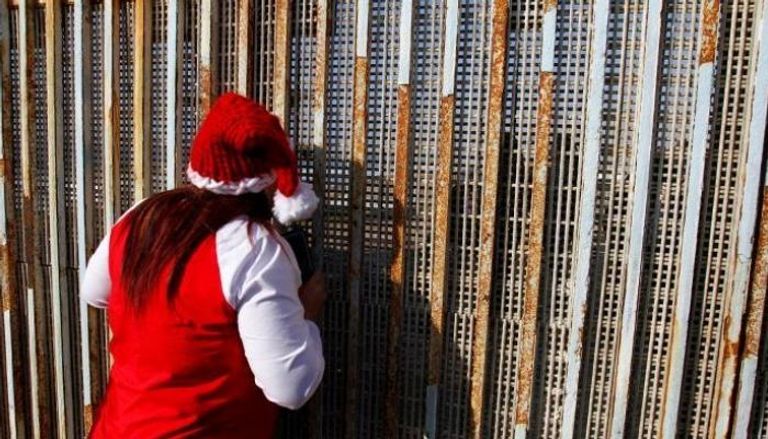 مكسيكية تتحدث إلى أقاربها عبر الجدار الفاصل على حدود أمريكا- أرشيفية