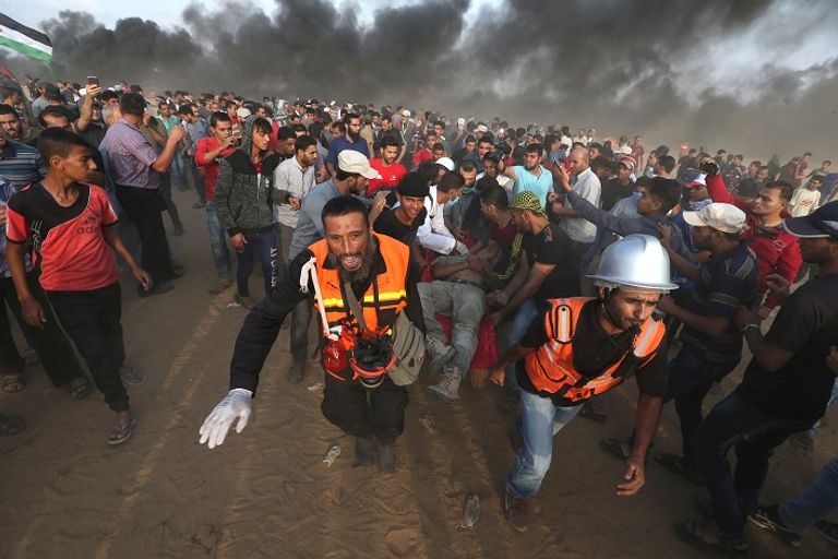 المسعفين يحملون أحد المصابين شباب من المشاركين في جمعة