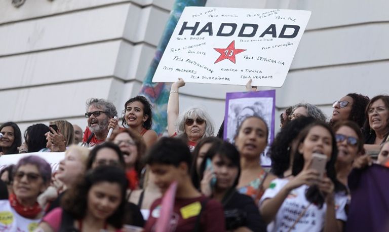 امرأة تحمل لافتة تأييد لحداد خلال الاحتجاجات - رويترز جانب من الاحتجاجات الرافضة لبولسونارو - رويترز