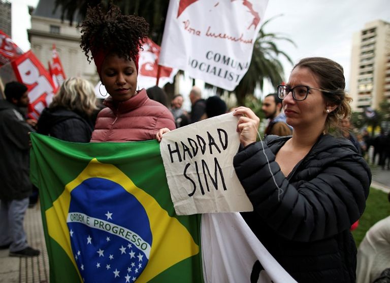 امرأة تحمل لافتة تأييد لحداد خلال الاحتجاجات - رويترز جانب من الاحتجاجات الرافضة لبولسونارو - رويترز