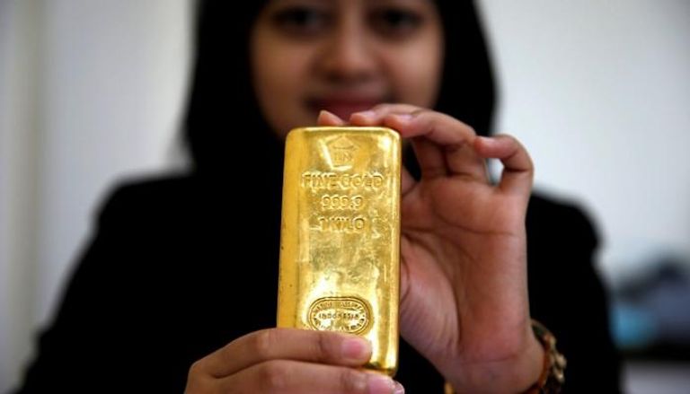 موظفة بالبنك المركزي في إندونيسيا تمسك بسبيكة ذهبية - أرشيفية